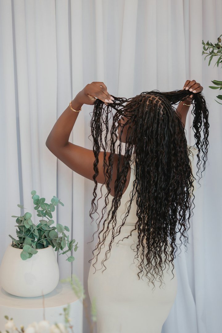 Femme de dos coiffant ses longues tresses