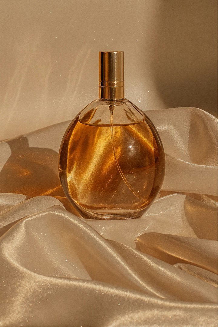 Flacon de parfum ambré posé sur un satin doré
