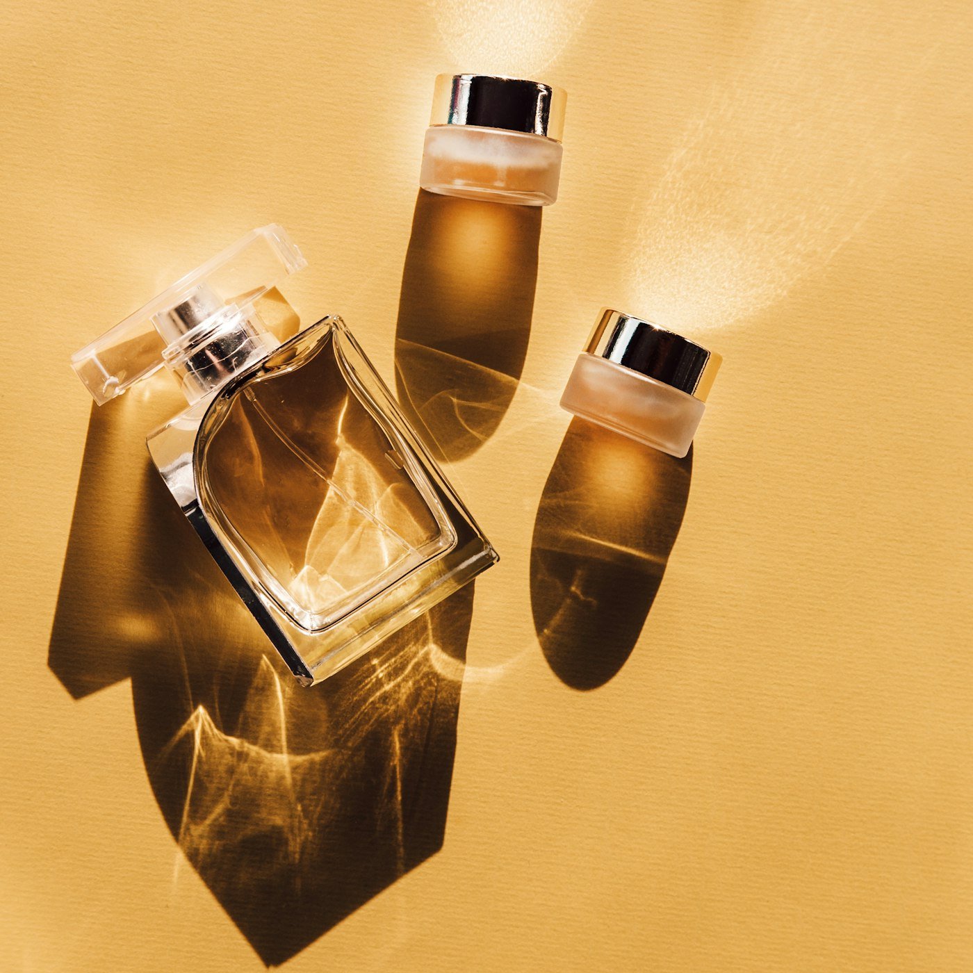 Flacons de parfum dorés dans une lumière chaude